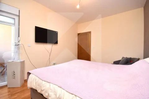Spavaća soba sa bračnim krevetom, televizorom na zidu i izlazom na terasu. - image 8