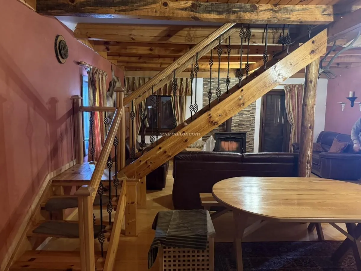 Dnevna soba sa drvenim stepeništem i kaminom.