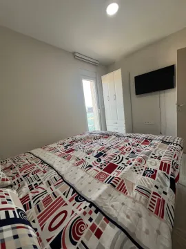 Furnished bedroom with a double bed, wardrobe, and television. - image 5