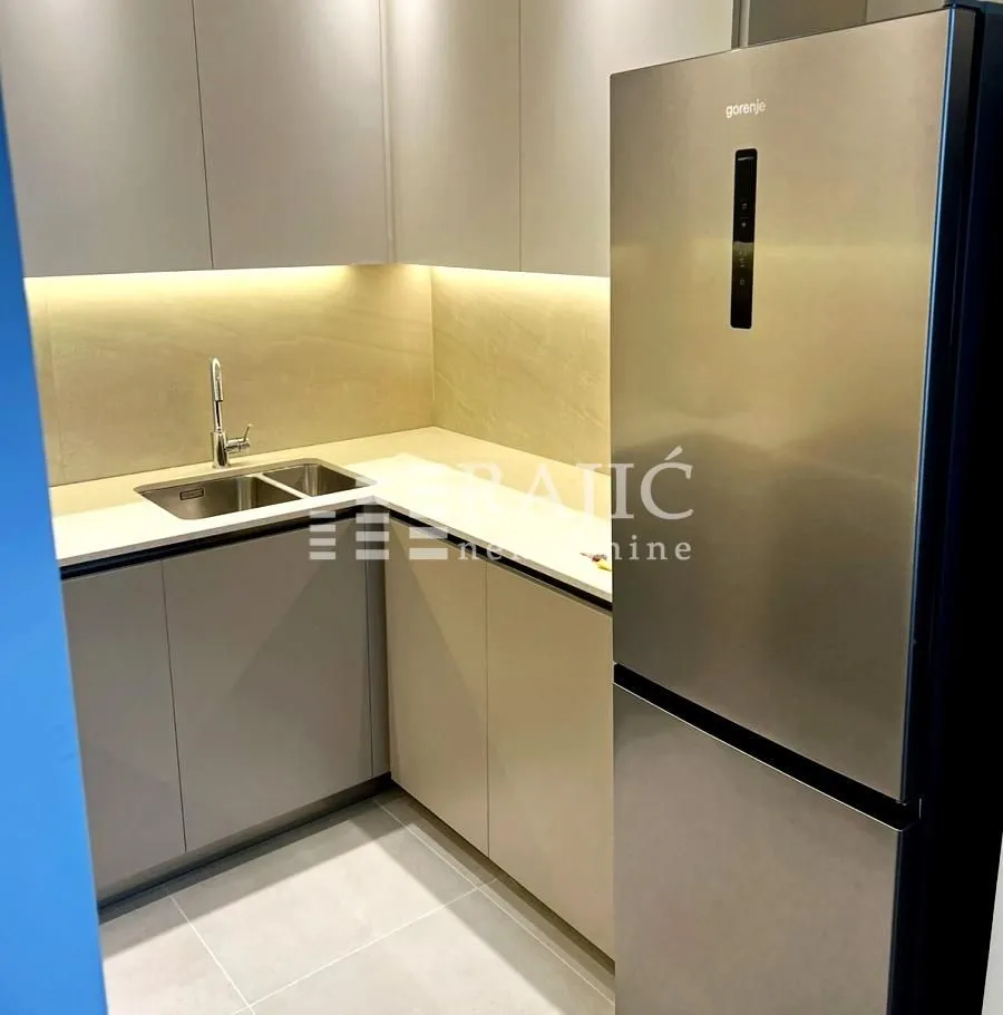 Modern kitchen with a sink, built-in cabinetry, and a refrigerator.