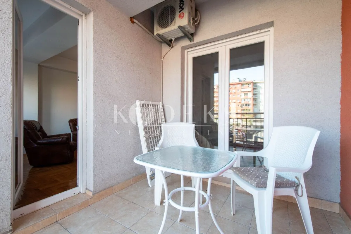 Manji natkriveni balkon sa garniturom za sjedenje.