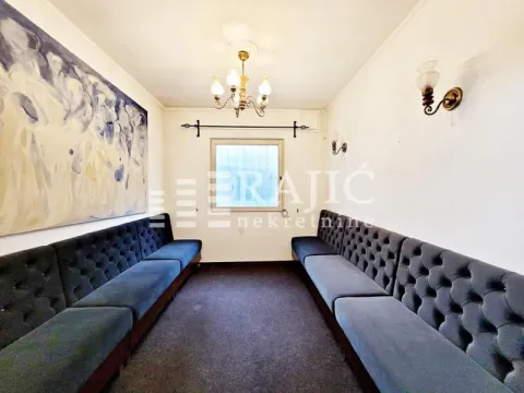 Long room with upholstered benches and a large piece of art on the wall. - image 12