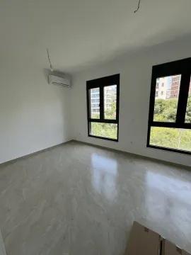 An empty and bright room with large windows and tiled flooring. - image 2
