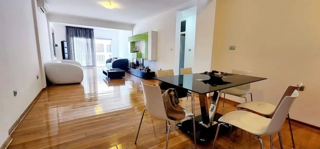 Spacious living room with a dining area and parquet flooring.