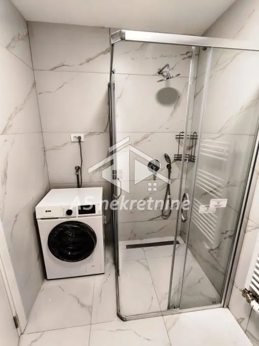 Bathroom with a shower cabin and a washing machine.