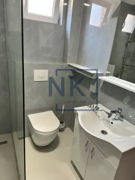 Modernly equipped bathroom with a walk-in shower, washbasin, and toilet. - image 10