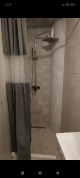 Shower enclosure with a curtain and modern faucet in the bathroom. - image 6