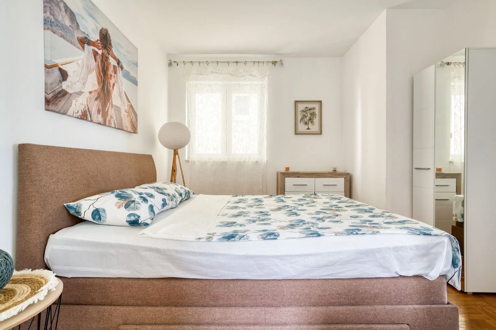 Bright bedroom with a double bed, window, and wardrobe.