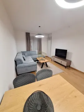Living room with a corner sofa, TV and dining table in the foreground. - image 4