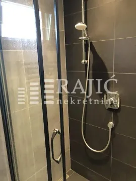 Shower cabin with dark tiles and modern faucet. - image 19