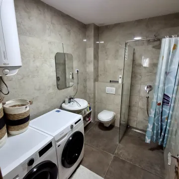 Kupatilo opremljeno tuš kabinom, umivaonikom, toaletom i mašinama za pranje i sušenje veša. - image 11