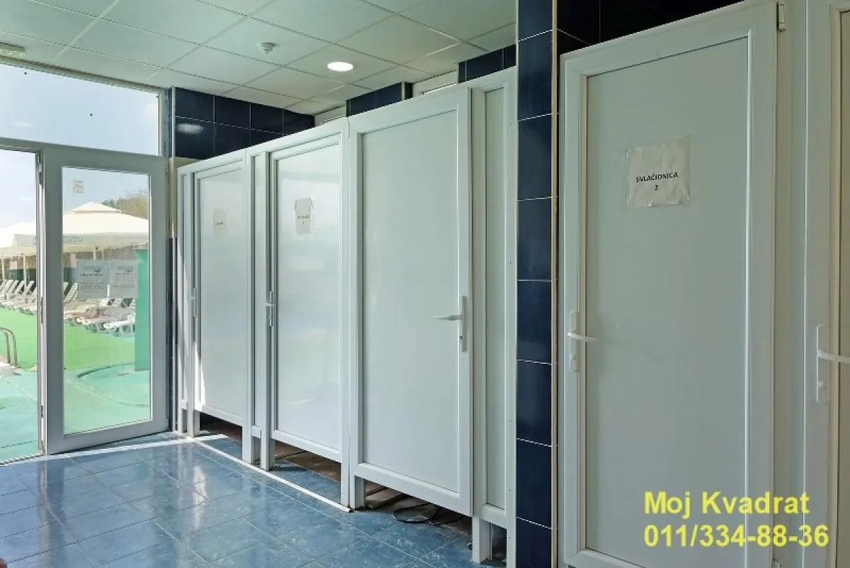 View of the cabins and doors with tiles on the floor and walls.