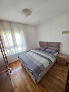 Opremljena spavaća soba sa bračnim krevetom, noćnim stočićima i prozorom. - image 5