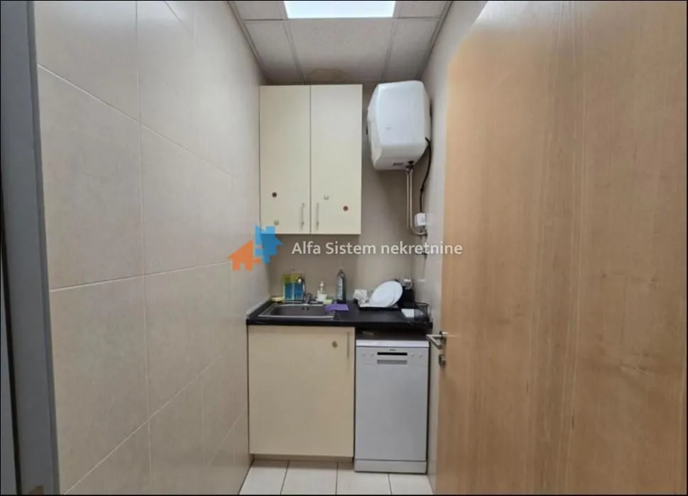 Small kitchenette with a sink, cabinets, and a dishwasher.