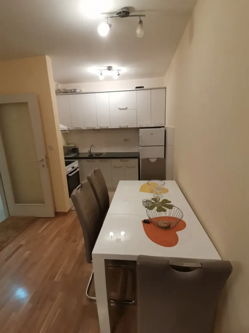 Kuhinja sa trpezarijskim stolom i stolicama.