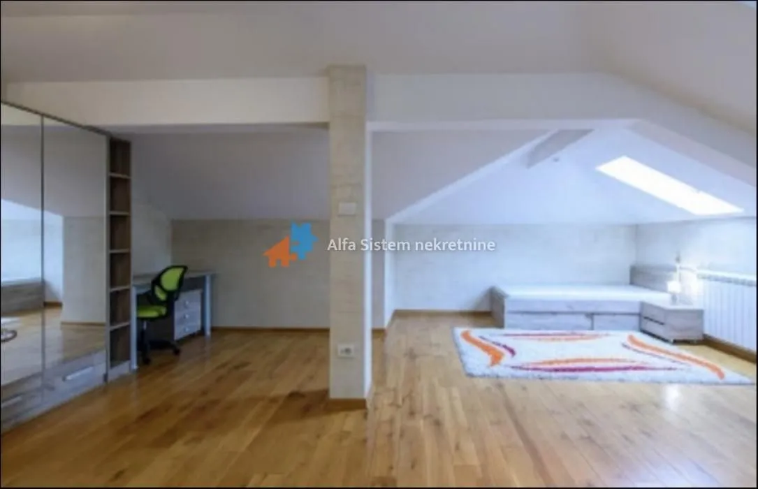 Attic space furnished as a bedroom with a bed, desk, and wardrobe.
