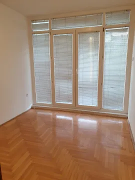 Bright empty room featuring parquet flooring and large balcony doors with blinds. - image 6