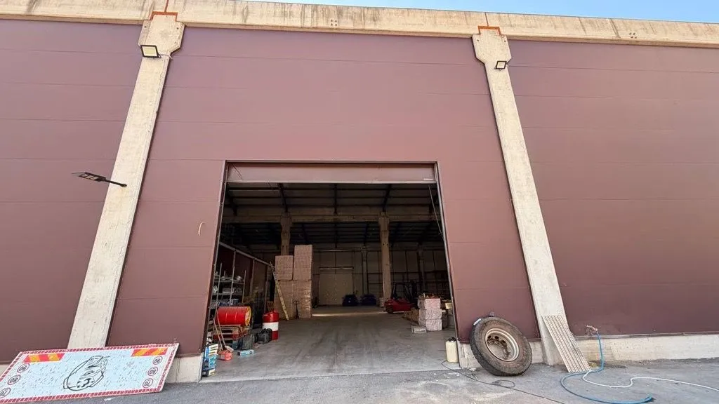 Exterior view of a warehouse space with large entrance doors.