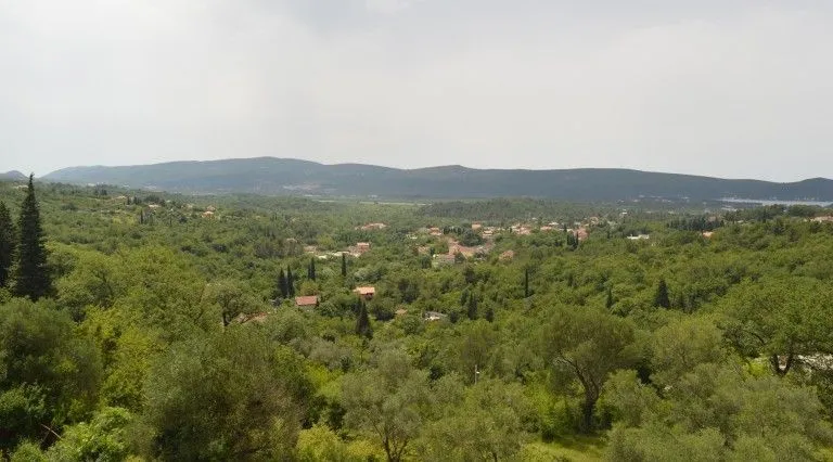 Pogled na zelene pejzaže i brda u daljini.