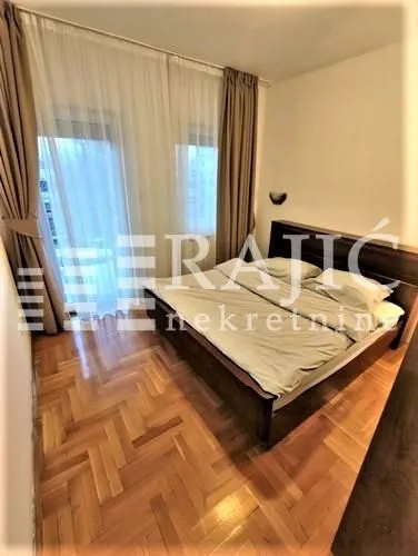 Bedroom with a double bed, parquet flooring, and access to the terrace.