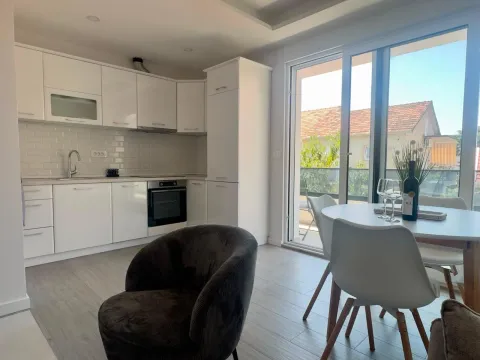 Modern kitchen with white cabinetry and a dining area. - image 4