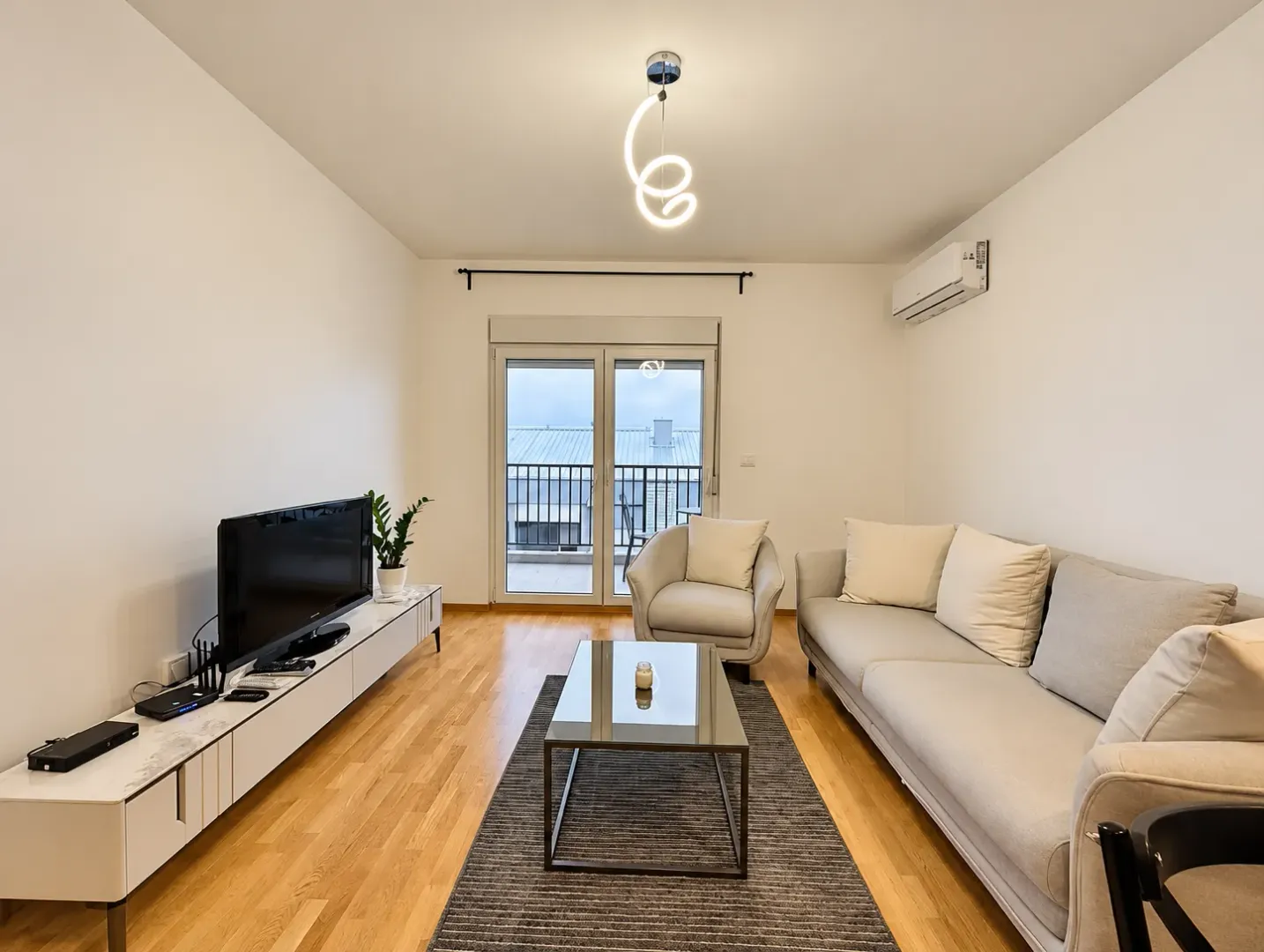 Living room with a sofa set, television, and access to the terrace.