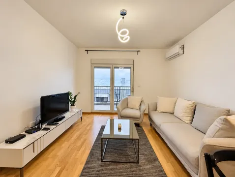 Living room with a sofa set, television, and access to the terrace. - image 2