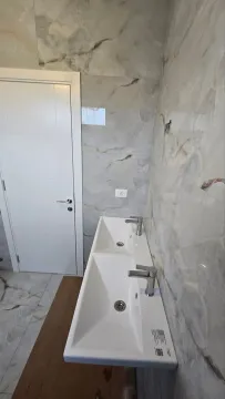 Moderne dvostruke umivaonike sa mermernim pločicama u kupatilu. - image 10