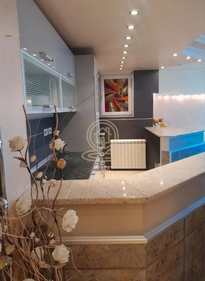 Modern kitchen with a bar counter and fitted units.