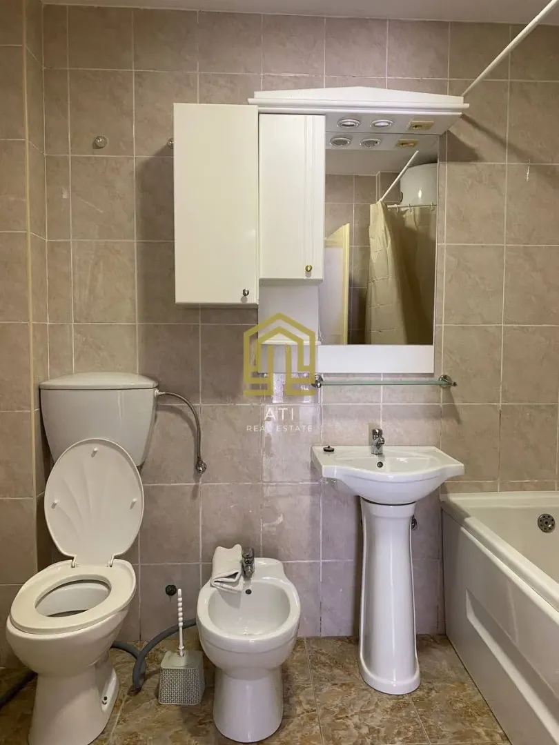 Pregledno opremljeno kupatilo sa sanitarijama i pločicama.