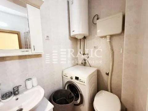 Smaller bathroom with sanitary facilities, a water heater, and a washing machine. - image 7