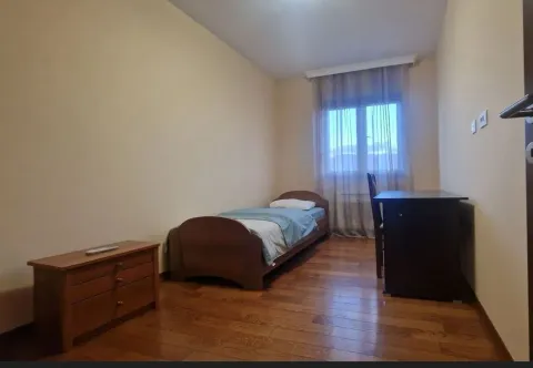 A simple bedroom with a single bed and a desk. - image 12
