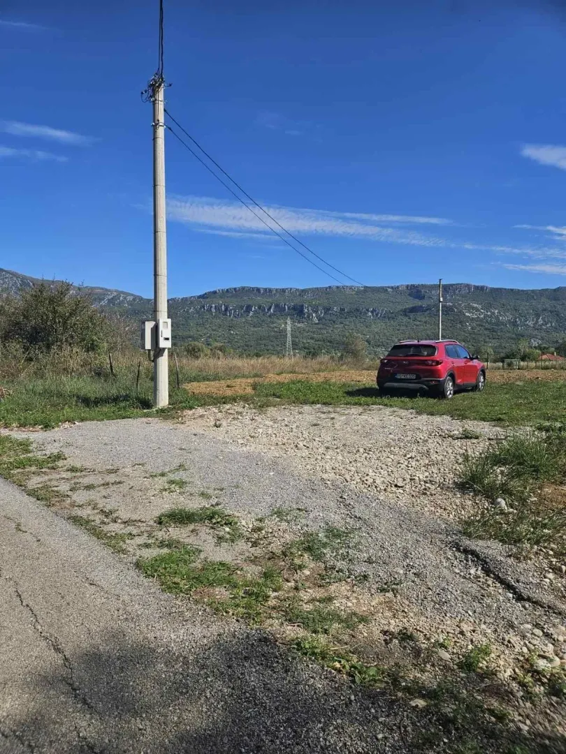 Plac sa pristupnim putem i pogledom na planine u daljini.