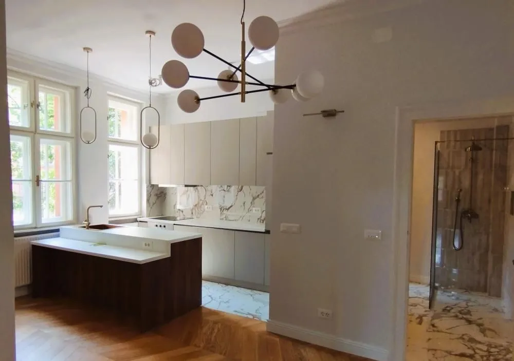 Modern kitchen with an island and dining area within an open space.
