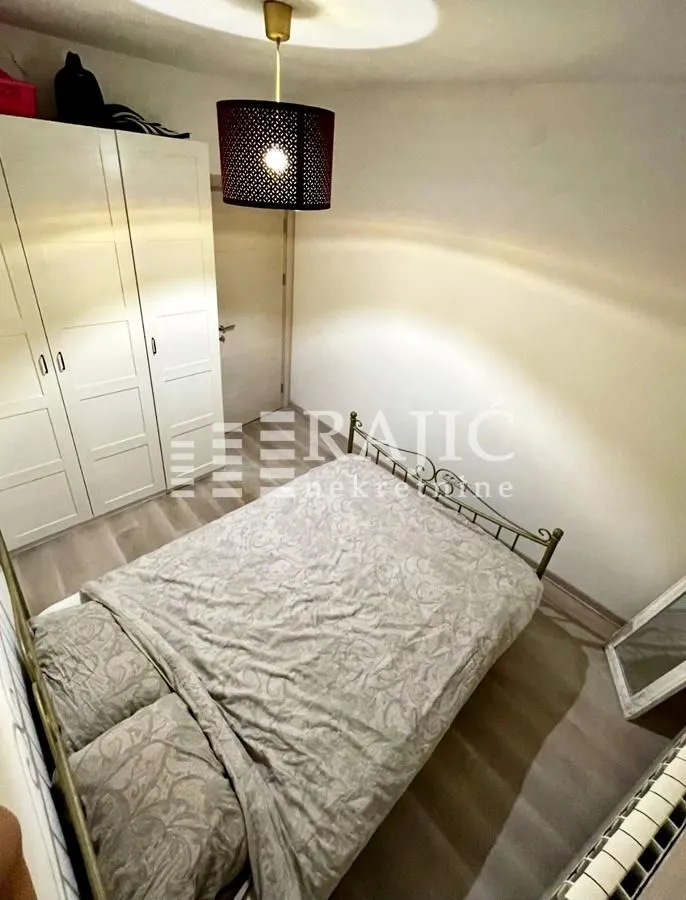 Furnished bedroom with a double bed and a wardrobe.