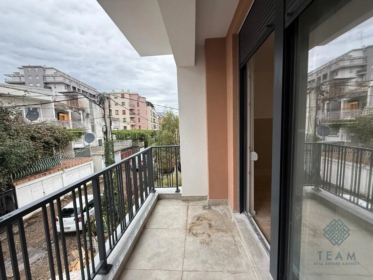 Nenamješten balkon sa pogledom na ulicu i zgrade.