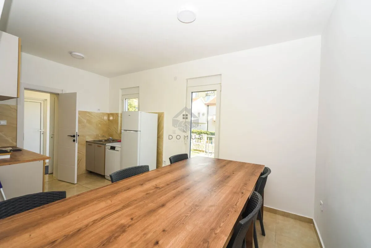 Kitchen with a dining table and a door leading to the terrace.