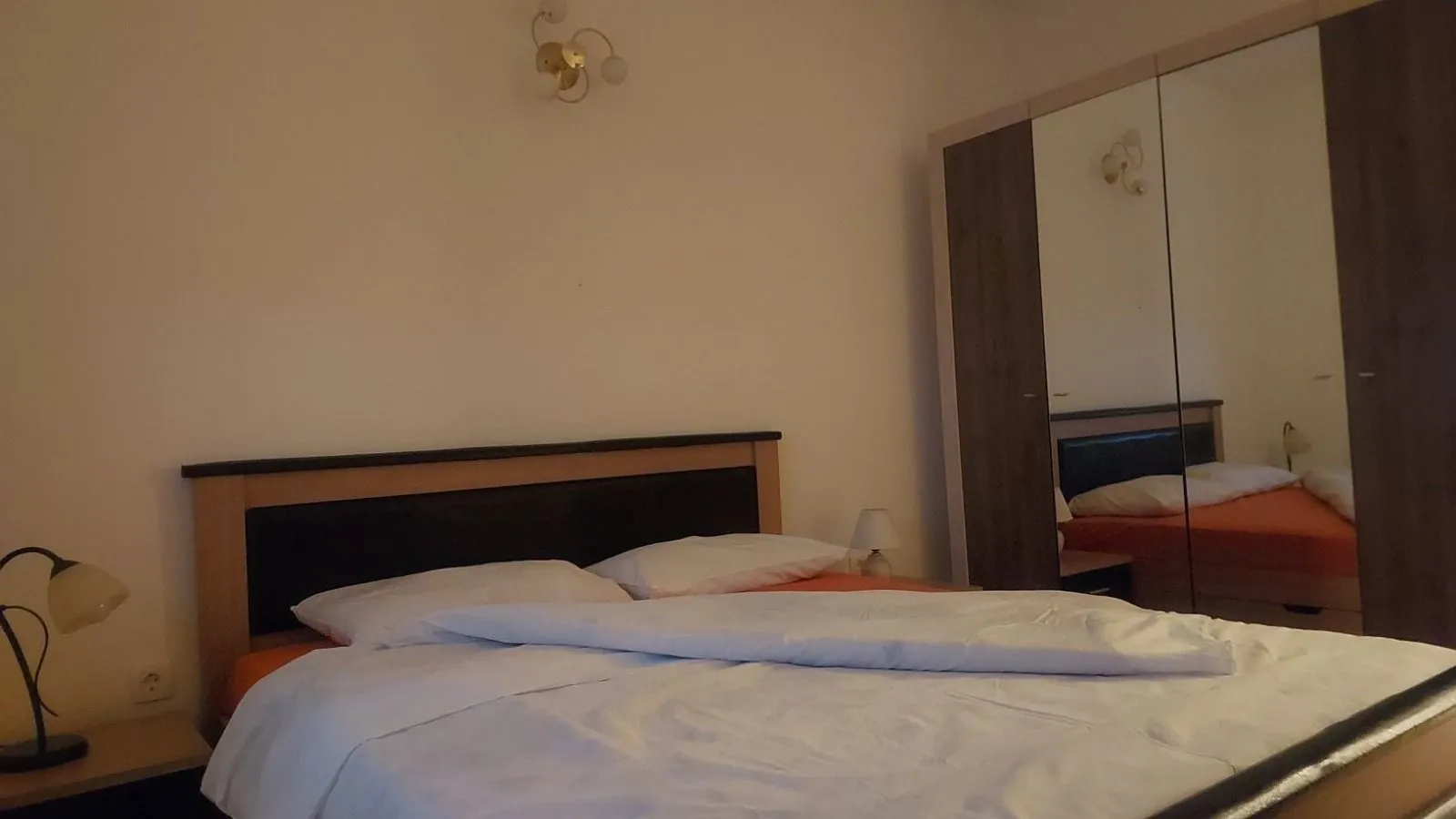Bedroom with a double bed and a large mirrored wardrobe.