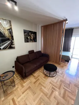 Dnevna soba sa braon trosjedom, stočićem i parketom na podu. - image 4