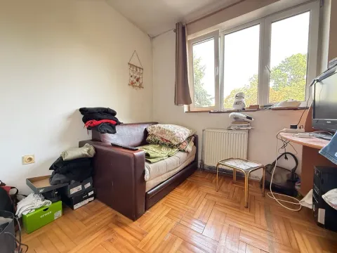 Manja soba sa kaučem, parketom i prozorom koji gleda na zelenilo. - image 5