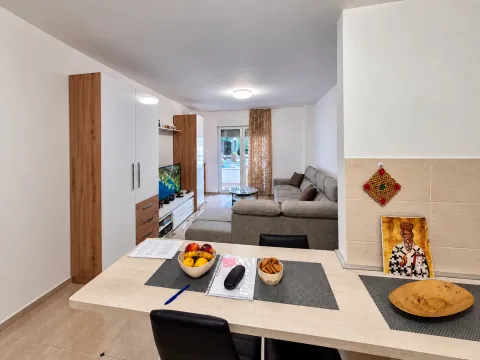 Dnevna soba sa garniturom, televizorom i trpezarijskim stolom u prvom planu. - image 3