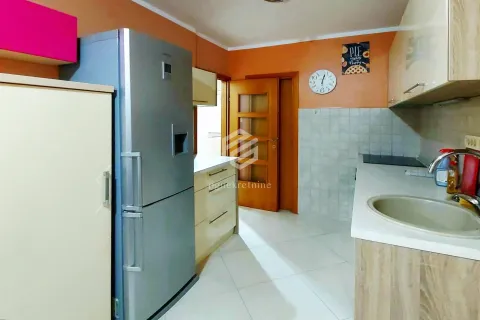 View of the kitchen with white cabinetry, refrigerator, and sink. - image 12