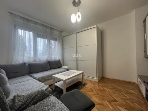 Living room with a sectional sofa, white wardrobe and parquet flooring. - image 3