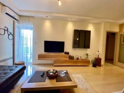 Spacious living room with a sofa and television.