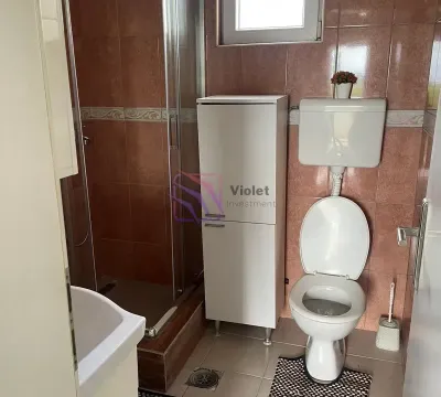 Bathroom with a shower cabin, toilet, and white cabinet. - image 15