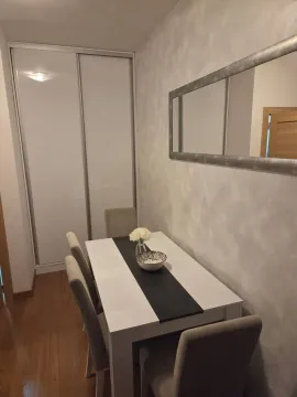 Trpezarija sa stolom, stolicama i velikim ogledalom na zidu. - image 6