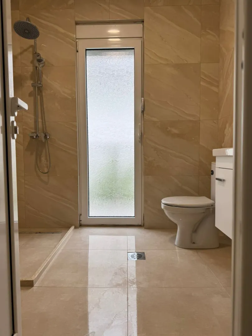 Bright bathroom with shower and toilet.