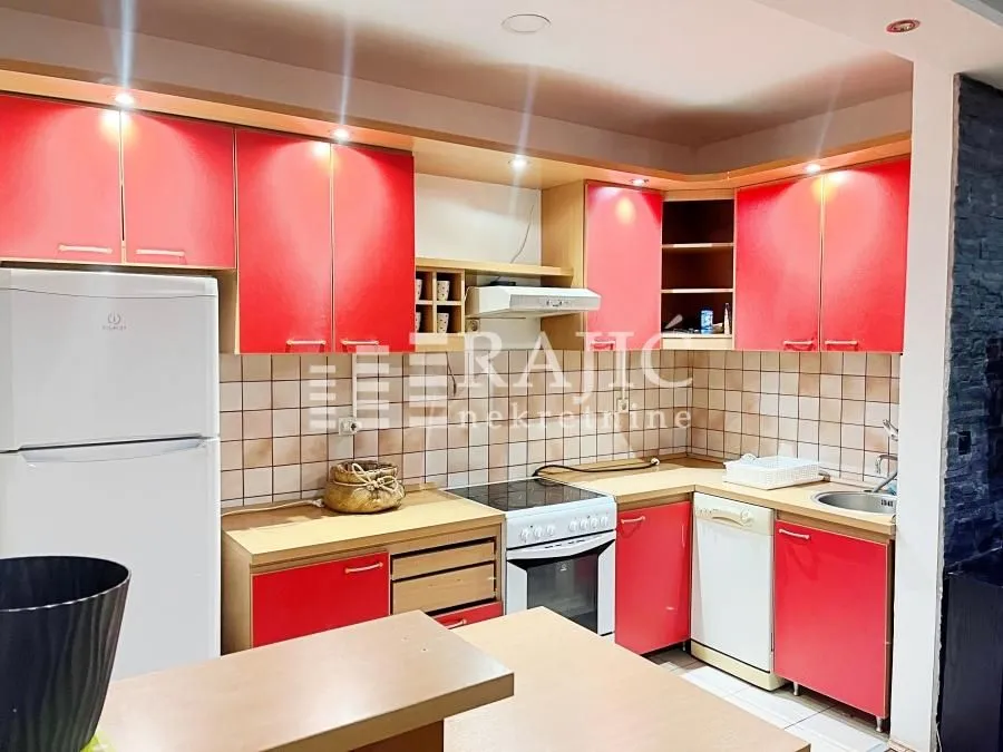 Equipped kitchen with red cabinets and built-in appliances.