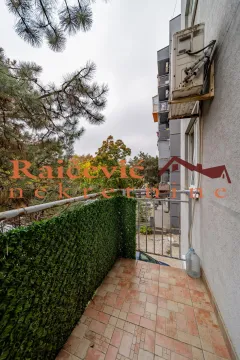 View from the tiled balcony overlooking surrounding buildings and trees. - image 4