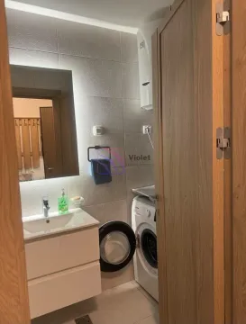 View of a small bathroom with a washbasin and a washing machine. - image 4